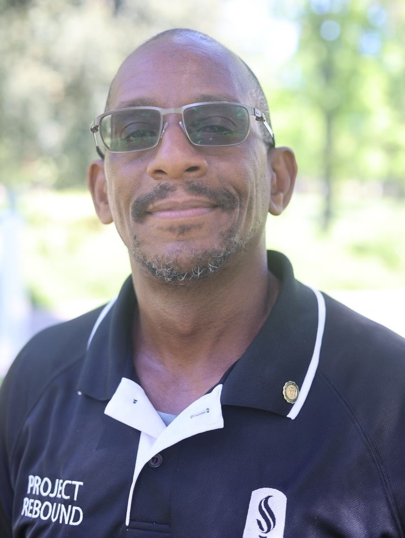 Michael Love wearing a dark polo shirt